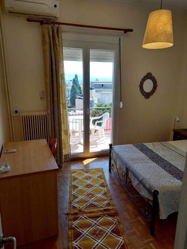 een slaapkamer met een bed en uitzicht op een balkon bij Ηλιαχτίδα Iliachtida apartment in Chios