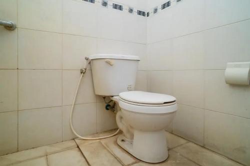 a bathroom with a toilet with a hose at Puri Saras Bintaro Syariah Mitra RedDoorz in Jurangmanggu