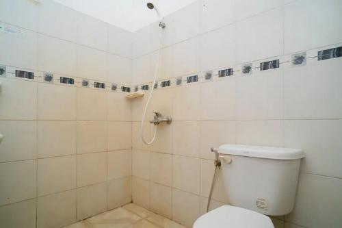 uma casa de banho com um chuveiro e um WC. em Puri Saras Bintaro Syariah Mitra RedDoorz em Jurangmanggu