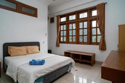 een slaapkamer met een bed met een blauwe doos erop bij Puri Saras Bintaro Syariah Mitra RedDoorz in Jurangmanggu