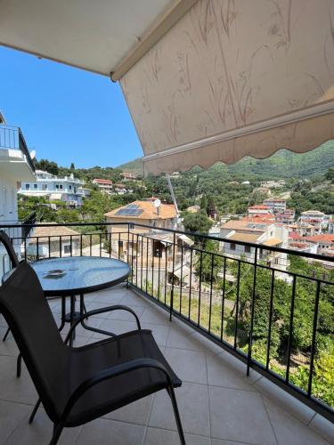 a balcony with a table and chairs and a view at Avdikos House in Parga