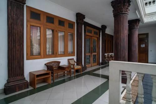 a lobby with columns and chairs in a building at Puri Saras Bintaro Syariah Mitra RedDoorz in Jurangmanggu