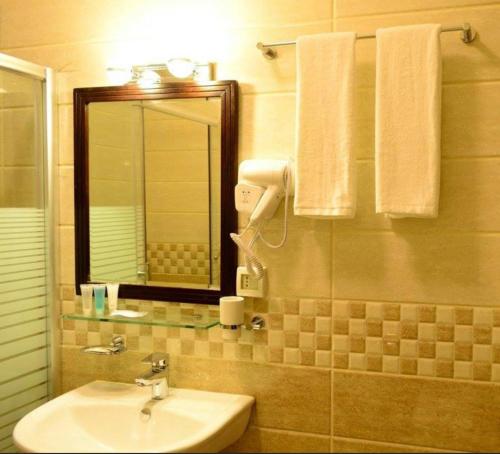 a bathroom with a sink and a mirror at Olive Hotel Amman in Amman