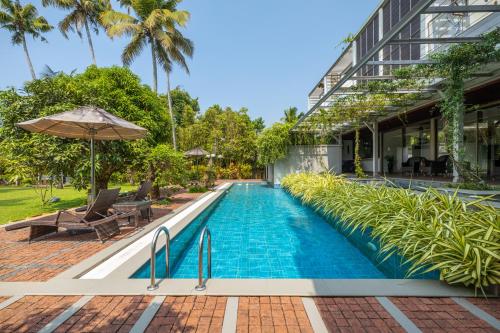 una piscina a sfioro di fronte a un edificio di ama Stays & Trails Sherlys Ente Kumbalanghi, Kochi a Tekkumuri