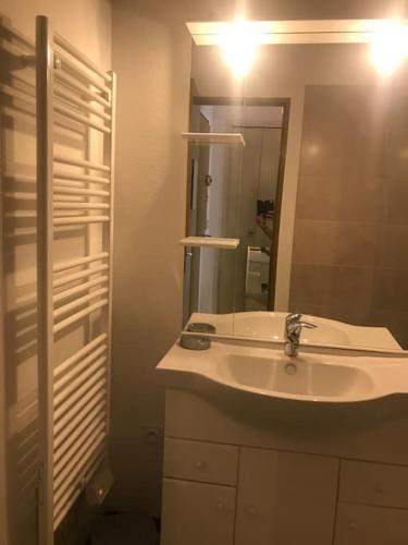 y baño con lavabo y espejo. en Appartement lumineux et rénové, en Digne-les-Bains