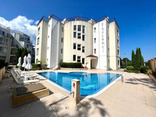 Un gran edificio con una piscina en frente. en Студио Галерия - Studio Galeria, en Byala