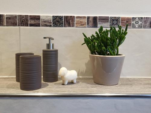 a shelf with three bottles and a potted plant at Haus Theda in Fockbek