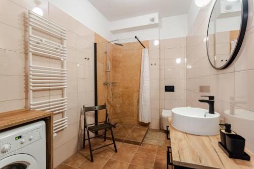 a bathroom with a sink and a washing machine at Very Berry - Różana 21 - Deluxe Apartments, check in 24h - in Poznań