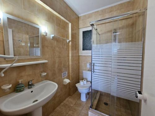 a bathroom with a sink and a shower and a toilet at Corfu Glyfada Menigos Resort 149 in Glyfada