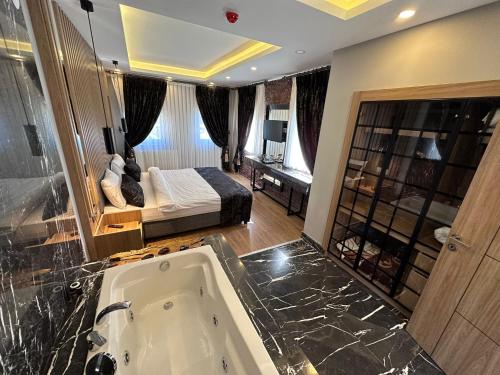 ein Badezimmer mit einer Badewanne und ein Schlafzimmer mit einem Bett in der Unterkunft Kaya Life Resort in Uzungöl