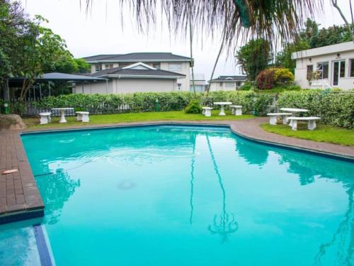 uma piscina com água azul em frente a uma casa em 3 Umzimkulu em Melville