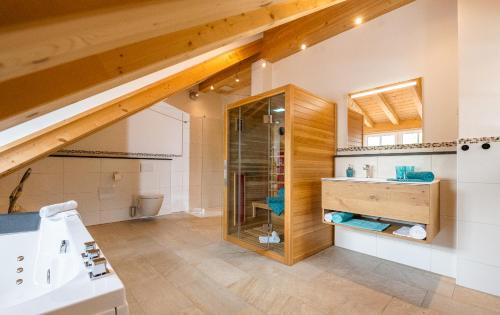 ein Bad im Dachgeschoss mit einem Waschbecken und einer Dusche in der Unterkunft Ferienwohnungen Zober am Mühlbach in Oberammergau