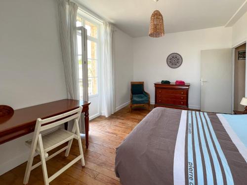 ein Schlafzimmer mit einem Bett, einem Schreibtisch und einem Stuhl in der Unterkunft Maison Sainte-Sabine Castels in Castels