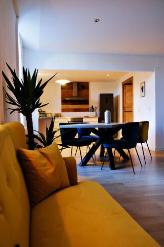a living room with a yellow couch and a table at Le Loft Pasteur in Dole