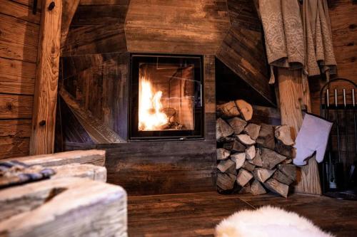 a fireplace in a room with a pile of logs at Troadkasten - Nationalpark Kalkalpen in Ramsau