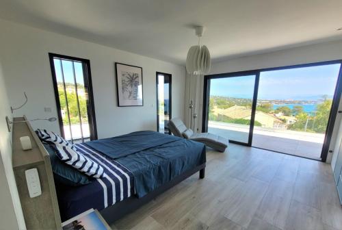 - une chambre avec un lit et de grandes baies vitrées dans l'établissement Très belle villa neuve 12 personnes, clim, piscine, dans le golfe de St-Tropez, à Saint-Peïre-sur-Mer