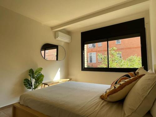 a bedroom with a bed with a large window at Superflat near beach 15' center in Sant Adria de Besos