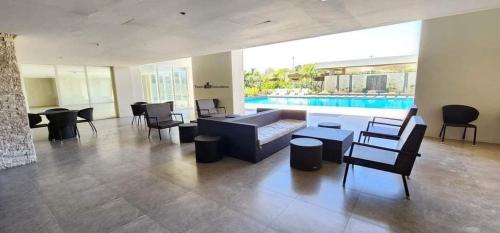 sala de estar con sofá, sillas y piscina en Mesavirre Garden Residence en Bacólod