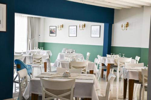 a dining room with white tables and chairs at Mimoza Beach Hotel in Yenibosazici