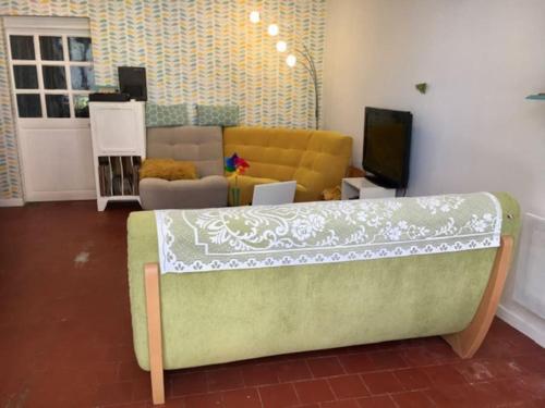 Una sala de estar con un sofá y un televisor. en Maison face à l'étang, en Précy