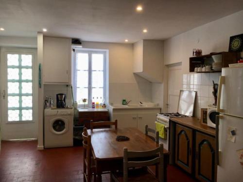 a kitchen with a table and a kitchen with a refrigerator at Maison face à l'étang in Précy