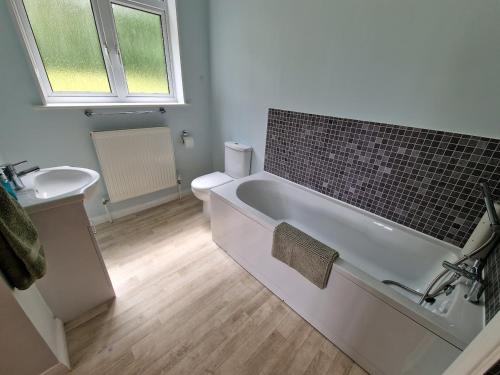 a bathroom with a bath tub and a sink at Country retreat near sea and South Downs, on National Cycle Network in Polegate