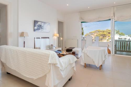een witte slaapkamer met een bed en een tafel en stoelen bij Casa Rosselló in Sant Feliu de Guixols