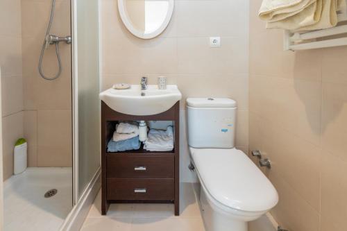 een badkamer met een wastafel, een toilet en een spiegel bij Casa Rosselló in Sant Feliu de Guixols