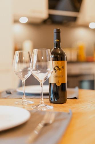 a bottle of wine and two wine glasses on a table at Merano City Living in Merano