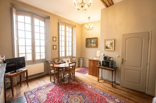 un salon avec une table et une salle à manger dans l'établissement L'Hotel de Panette, entrée sainte Chapelle - Cathédrale, à Bourges