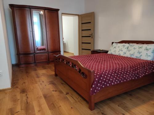 a bedroom with a bed and a wooden floor at Apartament Zielony in Włodawa
