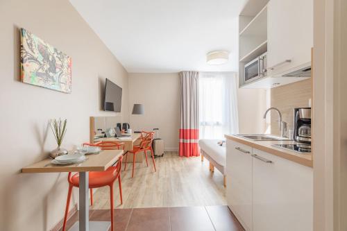 a kitchen and living room with a table and chairs at Appart'City Confort Bordeaux Chartrons in Bordeaux