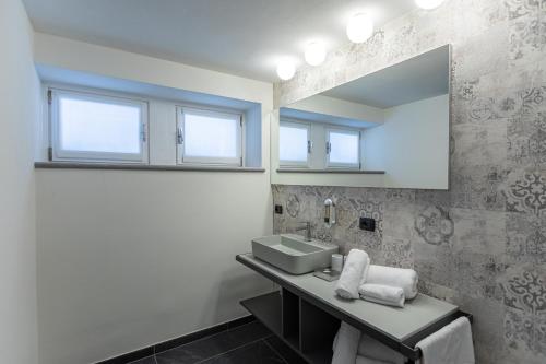 y baño con lavabo y espejo. en HARTMANN FEEL AT HOME B&B Villa Gignese en Gignese