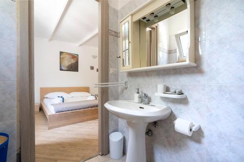 ein Bad mit einem Waschbecken, einem Spiegel und einem Bett in der Unterkunft Villa Blanca - Villa intera con trullo e piscina in Putignano