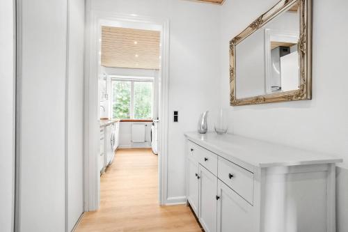 een witte badkamer met een spiegel en een wastafel bij Cozy 2-Bed Apartment in Aalborg in Aalborg