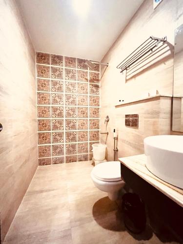 a bathroom with a white toilet and a sink at Hotel The Onix in Dehradun