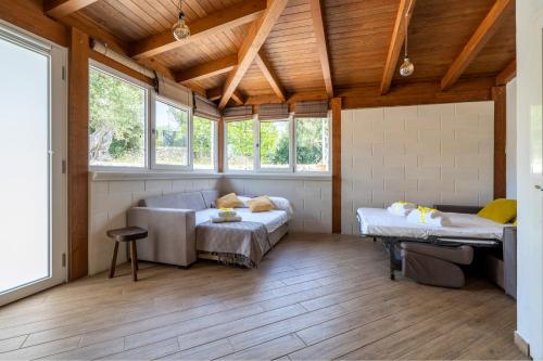 Zimmer mit Sofa, Bett und Fenstern in der Unterkunft Villa Blanca - Villa intera con trullo e piscina in Putignano