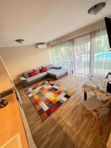 a living room with a couch and a rug at Gold Sea Apartman in Siófok