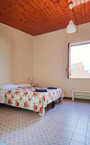 a bedroom with a bed in a room with a window at SantOliva Apartments in Trabia