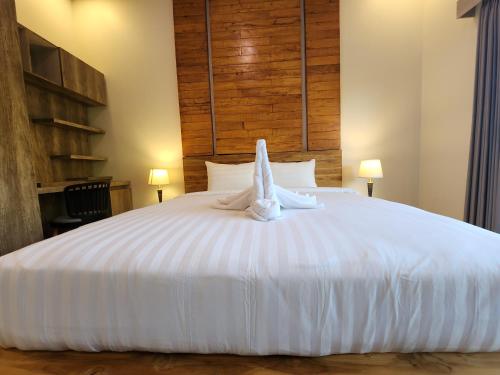 a white bed with a towel animal on it at Taman Dari Villa in Sudaji