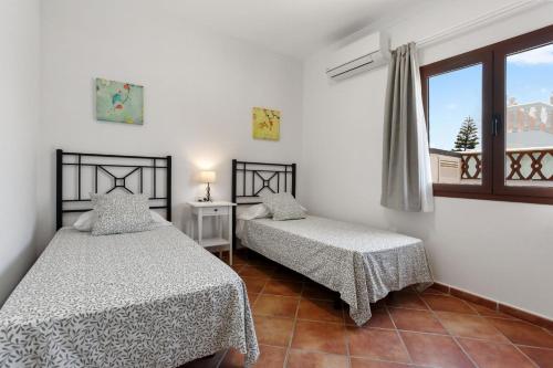 two beds in a room with a window at Villa Thomas in Corralejo
