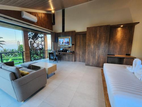 a living room with a couch and a tv at Taman Dari Villa in Sudaji
