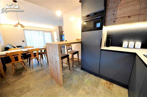 a kitchen and dining room with a table and a refrigerator at Abete Rosso Nuovissimo ed in centro a Livigno in Livigno