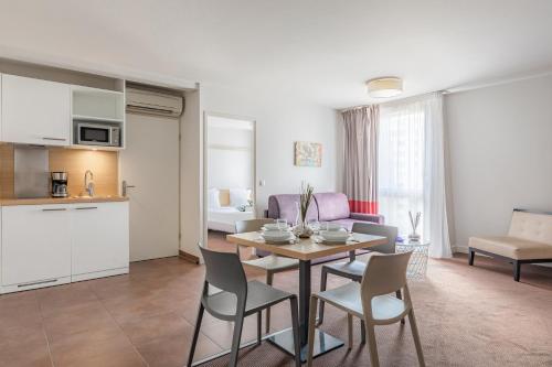 a kitchen and a living room with a table and chairs at Appart'City Confort Bordeaux Chartrons in Bordeaux