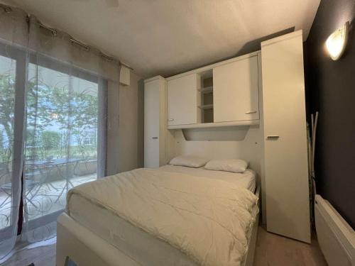 Habitación pequeña con cama y ventana grande. en Appartement La Rochelle, 1 pièce, 2 personnes - FR-1-246-121, en La Rochelle