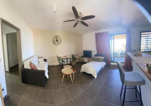 een woonkamer met een bed en een plafondventilator bij LE LAGON La Saline Les Bains vue mer, piscine in La Saline les Bains