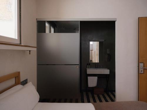 een slaapkamer met een deur naar een badkamer met een wastafel bij Guest House Ibaia Et Arramak in San Sebastian