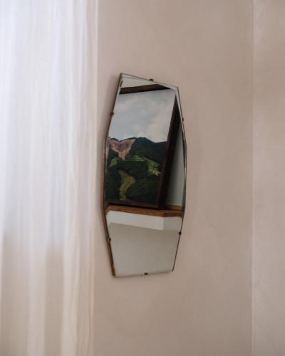 a mirror hanging on a wall next to a curtain at Guest House Ibaia Et Arramak in Donostia-San Sebastián