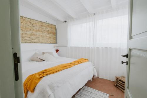 a bedroom with a bed with an orange blanket on it at Casa Astura in Capo dʼOrlando