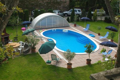 布達佩斯的住宿－Manzard Panzio，享有带遮阳伞的游泳池的顶部景致